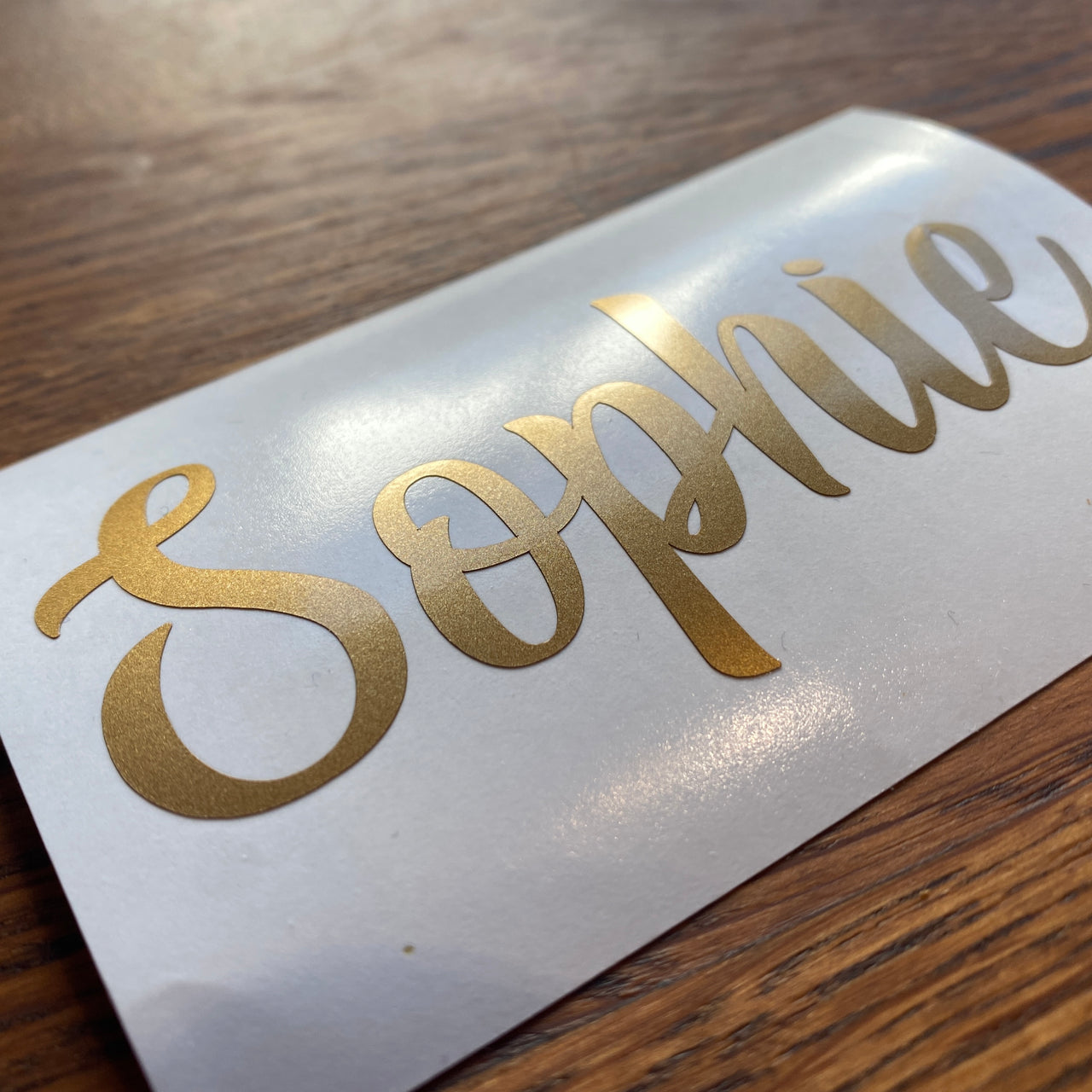 A metallic gold decal with the name Sophie cut out